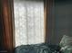 Calm bedroom setting with curtains filtering light over the bed and wall at 10997 Sardinia Sands Dr, Las Vegas, NV 89141