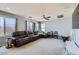 Spacious living room with a large, comfortable brown leather sofa and bright natural light at 10997 Sardinia Sands Dr, Las Vegas, NV 89141