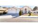 Front view of a charming house with a two-car garage and landscaped yard at 1540 Castle Crest Dr, Las Vegas, NV 89117