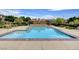 Community pool with lounge chairs and a fire pit area at 2428 Granada Bluff Ct, Las Vegas, NV 89135