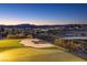 Elevated backyard view showcasing a putting green and city lights at 2446 Hardin Ridge Dr, Henderson, NV 89052