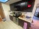 Dark wood kitchen cabinets, stainless steel appliances, and tile countertops at 4111 Sanderling Cir # 354, Las Vegas, NV 89103