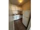 Small kitchen with white cabinets, stove, refrigerator, and tiled floor at 4600 University Center Dr # 95, Las Vegas, NV 89119