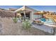 Modern backyard with pool, lounge chairs, and outdoor dining near retaining wall at 623 Dragon Mountain Ct, Henderson, NV 89012