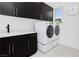 Modern laundry room with dark cabinetry and new appliances at 818 Meyer May St, Las Vegas, NV 89138