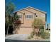 Two-story house with tan siding, a two-car garage, and landscaping at 10371 Calypso Cave St, Las Vegas, NV 89141