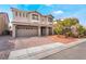 Two-story home featuring a brick driveway, a two-car garage, and well-maintained landscaping at 10529 Parthenon St, Las Vegas, NV 89183