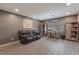 Cozy living room with hardwood flooring, a comfortable couch, a desk, and plenty of storage at 10529 Parthenon St, Las Vegas, NV 89183