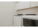 Laundry room with Whirlpool washer and dryer, and overhead cabinets at 10718 Glowing Dawn Ave, Las Vegas, NV 89135