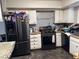 Kitchen with white cabinets, black appliances, and patterned backsplash at 2180 Palora Ave, Las Vegas, NV 89169