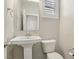 Small bathroom with pedestal sink, toilet and window at 266 Cullerton St, Las Vegas, NV 89148