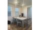 Bright dining room featuring a table set for four, modern lighting, and plenty of natural light at 43 Strada Loreto, Henderson, NV 89011