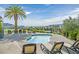 Inviting hot tub with lounge chairs overlooking desert landscape and a community pool in the background at 43 Strada Loreto, Henderson, NV 89011