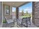 Inviting covered patio with stone pillars, comfortable seating, and a view of the backyard putting green at 43 Strada Loreto, Henderson, NV 89011