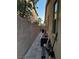 Long, narrow side yard with block wall, storage bin, and various tools at 4412 Desert Park Ave, North Las Vegas, NV 89085