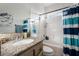 Bathroom with shower tub combo, granite countertop, and blue striped shower curtain at 4911 E Parkwood Dr, Pahrump, NV 89061