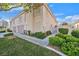 Tan two-story townhome with a gated entry and lush landscaping at 513 Rafkin Pl, Henderson, NV 89052