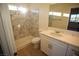 Modern bathroom with a shower/tub combo, white vanity, and marble tile at 521 Antelope Ave, Pahrump, NV 89060