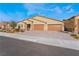 Tan three-car garage home with a well-manicured front yard and landscaping at 5260 Brayden Ct, Las Vegas, NV 89131