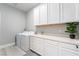 Bright laundry room with white cabinets and front-load washer and dryer at 5260 Brayden Ct, Las Vegas, NV 89131