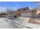 Two-story house with a tan exterior, green door and a two-car garage at 5313 Dawn Break Canyon St, North Las Vegas, NV 89031