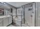 Well-lit primary bathroom with double sinks, tub, and glass enclosed shower at 5428 Brazelton St, North Las Vegas, NV 89081