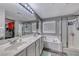 Well-lit primary bathroom with double sinks, tub, glass shower, and a large mirror at 5428 Brazelton St, North Las Vegas, NV 89081