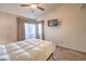 Bright bedroom features a ceiling fan, large window, and a wall-mounted television at 5655 Vineyard Ln # 0, Las Vegas, NV 89110