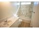 Bright bathroom featuring marble-style tile, a tub-shower combo, and white vanity at 5821 Genoa Ave, Pahrump, NV 89060