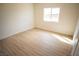 Bright, empty bedroom with a window and light wood-style floors at 5821 Genoa Ave, Pahrump, NV 89060