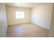 Bright, empty bedroom with a window and light wood-style floors at 5821 Genoa Ave, Pahrump, NV 89060