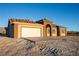 Tan stucco home with a white garage door and arched entryway at 5821 Genoa Ave, Pahrump, NV 89060