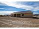 Rear view of the house showcasing the simple architectural design, backyard, and tile roof at 5821 Genoa Ave, Pahrump, NV 89060