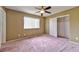 Spacious bedroom with a large window, fan, and closet, providing ample space and natural light at 6113 Breeders Cup St, Las Vegas, NV 89130