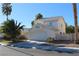 Two-story house with a white exterior, attached garage, and palm trees at 6113 Breeders Cup St, Las Vegas, NV 89130