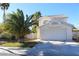 Two-story house with a white exterior, attached garage, and palm trees at 6113 Breeders Cup St, Las Vegas, NV 89130