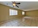 Neutral-toned living room featuring tile flooring and natural light from two windows at 6113 Breeders Cup St, Las Vegas, NV 89130