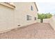 Side yard featuring a stucco exterior wall, gravel and a partial view of the backyard at 6113 Breeders Cup St, Las Vegas, NV 89130