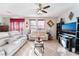 Living room with light beige couches, TV, and ceiling fan at 6255 W Arby Ave # 218, Las Vegas, NV 89118