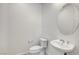 Clean and modern bathroom with a toilet, sink, and oval mirror at 650 Sentinel Spire St, Las Vegas, NV 89138