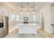 Modern kitchen with white cabinets, quartz island, and stainless steel appliances at 650 Sentinel Spire St, Las Vegas, NV 89138