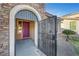 Inviting entryway with an arched metal gate and a purple door at 6819 Rolling Boulder St, Las Vegas, NV 89149