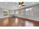 Living room with hardwood floors, kitchen view, and large windows with blinds at 6819 Rolling Boulder St, Las Vegas, NV 89149