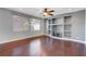 Living room with hardwood floors, built-in shelving and a ceiling fan at 6819 Rolling Boulder St, Las Vegas, NV 89149