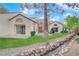 Serene backyard oasis with a patio, lush lawn, and a charming water feature at 6948 Emerald Springs Ln, Las Vegas, NV 89113