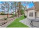 Landscaped backyard with a stone pathway and green grass at 6948 Emerald Springs Ln, Las Vegas, NV 89113