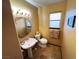 Small bathroom with pedestal sink and octagon mirror at 7732 Tinted Mesa Ct, Las Vegas, NV 89149