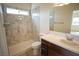 Modern bathroom featuring a walk-in shower with decorative marble tile and a vanity with a solid surface countertop at 801 Fort Churchill Rd, Pahrump, NV 89060