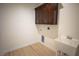 Laundry room with overhead cabinets, utility sink, and tile flooring at 801 Fort Churchill Rd, Pahrump, NV 89060