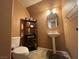 Small bathroom with pedestal sink, toilet, and shelving unit at 8384 Creek Canyon Ave, Las Vegas, NV 89113